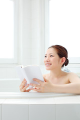 Obraz na płótnie Canvas 入浴中に読書をする女の子