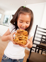 Young Girl Eating Stack of Cookies