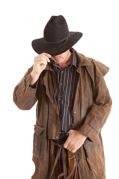 cowboy with duster holding hat