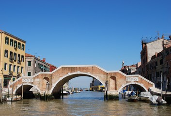 Fototapeta na wymiar Stone bridge with three arches on a canal in Venice, Italy