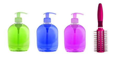 Colorful shampoo bottles and red massages comb isolated on white