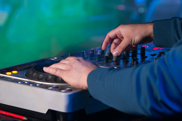Dj mixes the track in the nightclub at a party