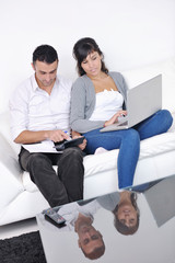 Fototapeta na wymiar joyful couple relax and work on laptop computer at modern home