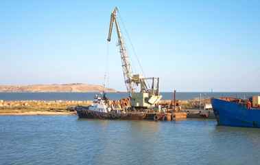 small ship and crane in dock