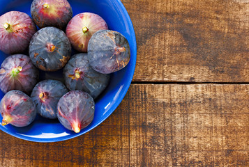 Bowl of ripe figs on rustic wooden table