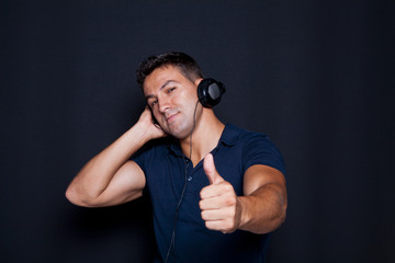 man with headphones on his ears and making ok sign