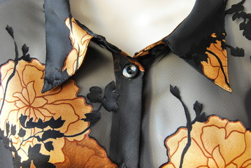 Ausschnitt - Kragen einer schwarzen Hemdbluse mit floralem Motiv