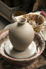 hands of a potter, creating an earthen jar on the circle