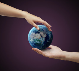 Male and female hand holding earth