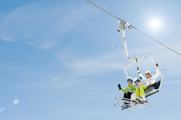 Skiers on ski lift - space for text