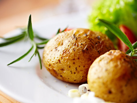 Baked potatoes with rosemary on a plate