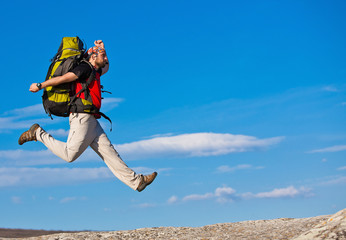 Hiker jumps on the rock