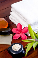Spa concept with zen stone, bath salt, soap and a red flower