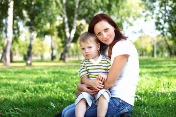 Young mother with her son in summer park