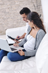 joyful couple relax and work on laptop computer at modern home