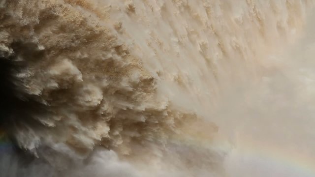 Strong flowing water from the open sluice gates of a large dam