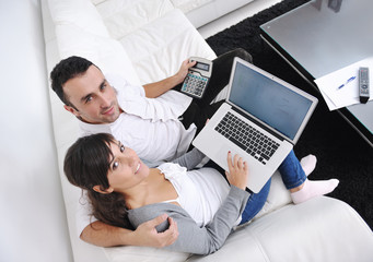 joyful couple relax and work on laptop computer at modern home