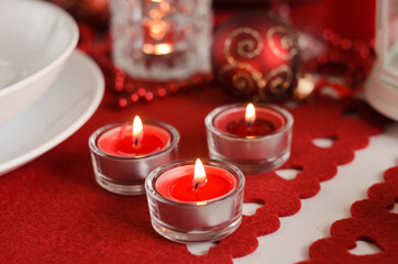 Obraz na płótnie Canvas christmas table - candles and decoration on red