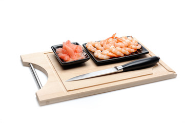 fresh shrimps and ingver on wooden board isolated. sushi ingredi
