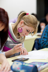 pretty, female college student sitting in a classroom