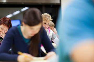 pretty, female college student sitting in a classroom