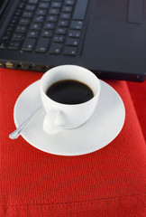 Tazzina di caffè vicino al computer