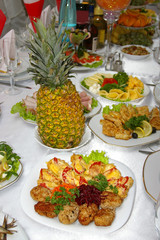 Plate with meat appetizers and whole pineapple