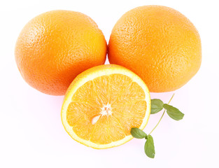 Oranges, one cut in half, on white background