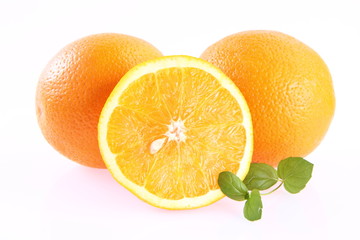 Oranges, one cut in half, on white background