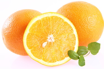 Oranges, one cut in half, on white background