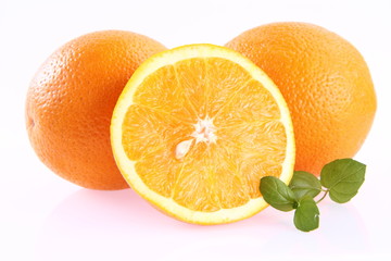 Oranges, one cut in half, on white background