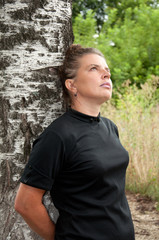 Russian middleaged woman stands of birch