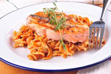 Lachssteak mit Thymian und Nudelsalat auf einem Teller