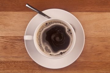 Coffee cup taken from overhead on wooden table