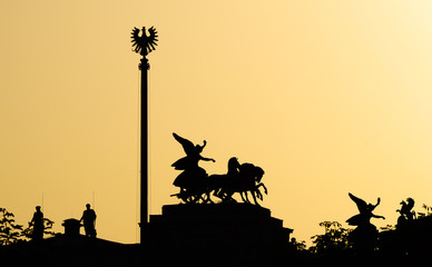 silhouette of statues against the sunset