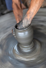 Hands of a potter, creating an earthen jar on the circle