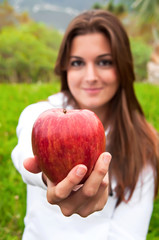 Young girl showing a red apple