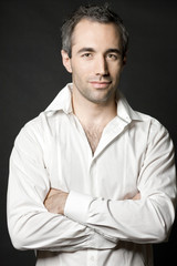 Obraz premium Handsome man posing in white shirt on dark background.