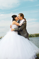 Fototapeta na wymiar Happy bride and groom against blue sky