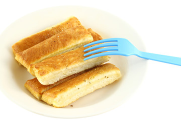 Bread stick in white disk with blue plastic fork.