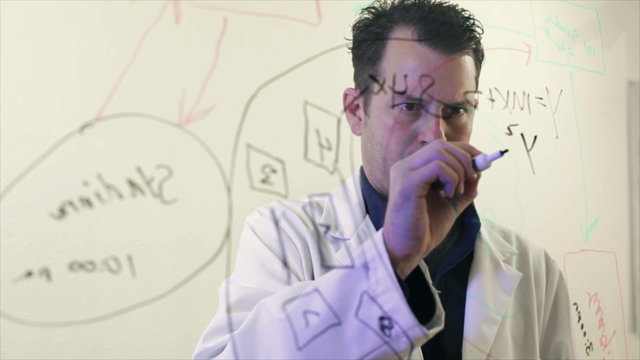 Scientist Writing on a Clear Board