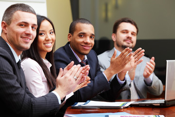 Multi ethnic business group greets you with clapping