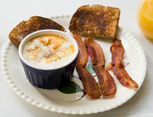 shirred eggs in ramekin with toast and bacon