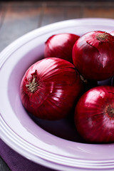 Closeup of red onions in a purple bowl