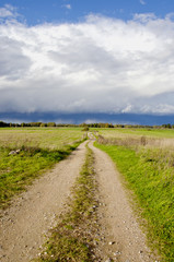 Fototapeta na wymiar countryside road and autumn rain clouds
