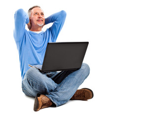 Mature man sitting on the floor with his laptop