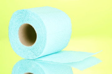 blue roll of toilet paper on green background