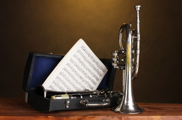 antique trumpet and clarinet in case on wooden table