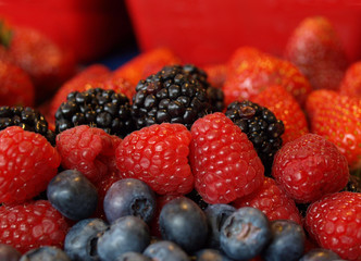 Colorful fresh berries on red background.