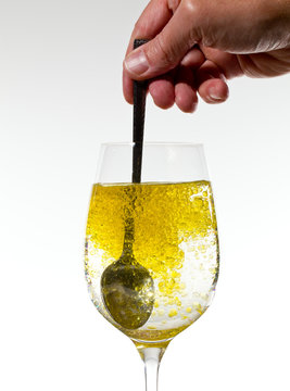 Olive oil being stirred in wine glass